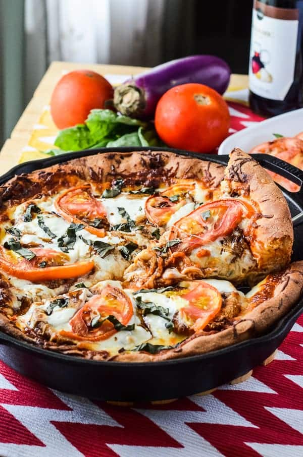 Eggplant Parmesan Caprese Skillet Pizza | A delicious deep dish caprese skillet pizza, layered with crispy baked eggplant parmesan, fresh tomatoes, spinach, &amp; basil, and creamy mozzarella cheese.