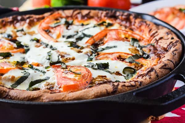Eggplant Parmesan Caprese Skillet Pizza | A delicious deep dish caprese skillet pizza, layered with crispy baked eggplant parmesan, fresh tomatoes, spinach, &amp; basil, and creamy mozzarella cheese.