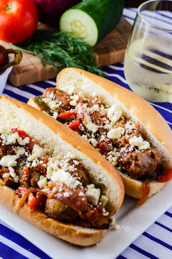 Greek-Style Sausage & Peppers Sandwich | A simply perfect classic sausage and peppers sandwich, made in one pan and taken to foreign places by the use of dill, cucumber, and Nikos® Feta Cheese!