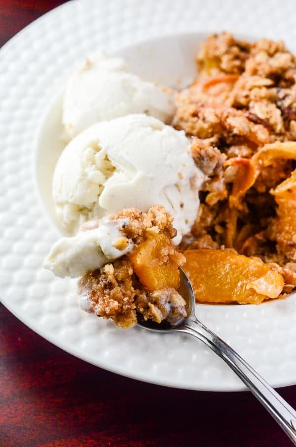 Cinnamon Ginger Peach Crisp | A a spicy, playful nod to fall, using one of summer's favorite fruits marinated in cinnamon whiskey and fresh ginger!