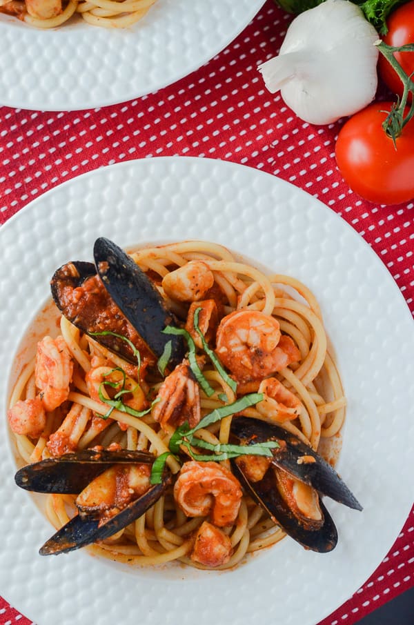 Seafood Fra Diavolo with Bucatini | Bucatini pasta, crowned with an array of fresh seafood that's bursting with spicy Italian flavor and lots of garlic - it's a spicy seafood spaghetti extravaganza!