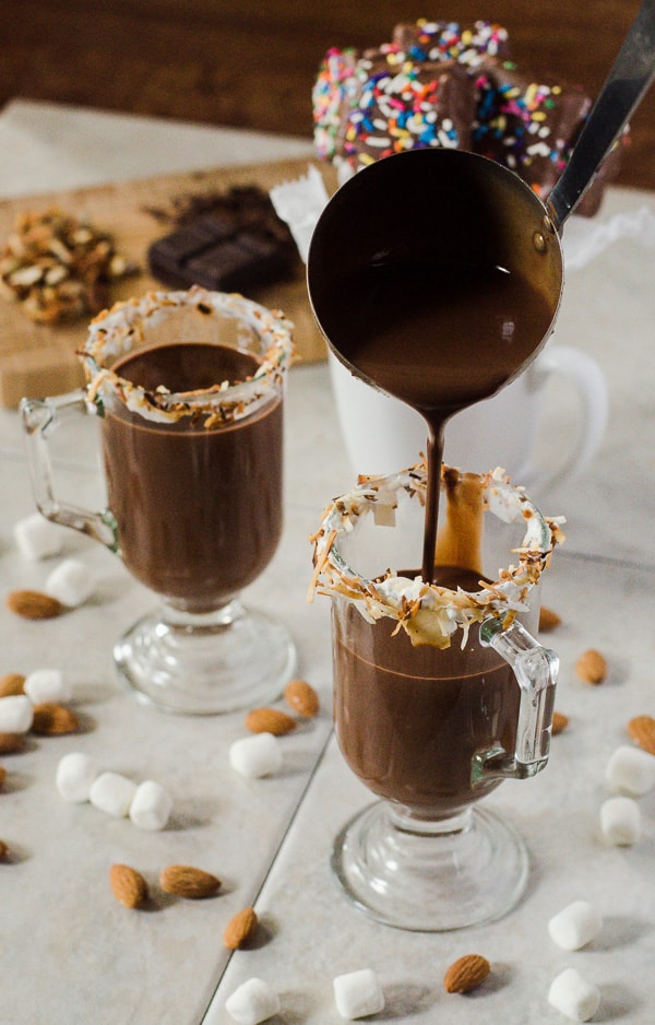 Toasted Coconut Almond Hot Cocoa | This delicious hot cocoa is made with real chocolate, cream of coconut, and almond milk, and garnished with all the goodness of an old favorite candy bar - it's a wonderfully satisfying way to warm up this winter!
