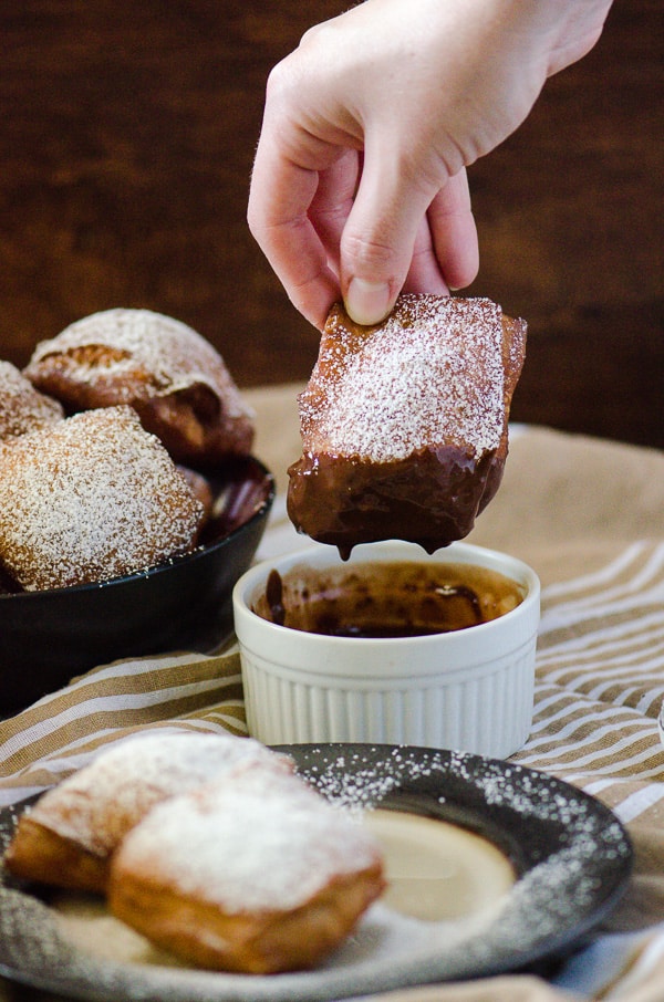Salted Caramel Beignets | Bring a little New Orleans into your kitchen - salted caramel flavored sweet dough beignets, deep-fried and served hot with a sweet chocolate dipping sauce!