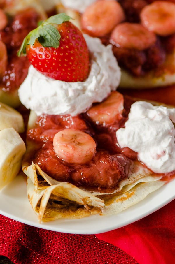 Strawberry Banana Hazelnut Cream Crepes | A beautiful breakfast treat for your sweetheart! Florida strawberries, fresh bananas, and hazelnut spread, rolled up in thin, delicious crepes, topped off with homemade strawberry whipped cream!