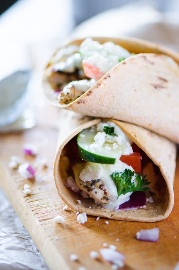 Souvlaki Chicken Wraps with Homemade Tzatziki | Flatbread stuffed with hummus, souvlaki chicken, veggies, feta cheese, and homemade tzatziki, these easy Greek-style wraps are perfect for lunch on the go or a fun Sunday Supper!