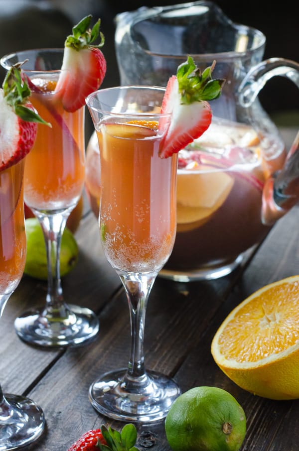 Brunch Sangria Mimosas | Can't decide between sangria or mimosa for brunch? Have both! Fresh fruit bathed in pineapple juice, champagne, and a little Creme de Cassis makes for a perfect weekend pick-me-up!