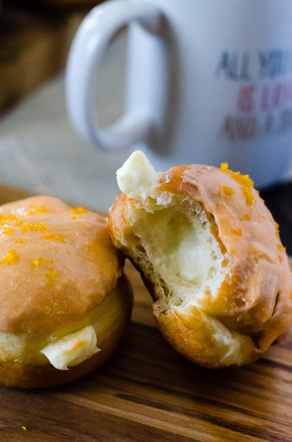 Orange Creamsicle Donuts | Your favorite childhood popsicle in donut form! Fried yeast donuts, stuffed with orange cream cheese filling, and topped with orange glaze. 