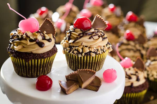Take a bite of cupcake heaven! Tender chocolate cupcakes, stuffed with hot fudge sauce and topped with peanut butter mousse, these decadent Peanut Butter Hot Fudge Sundae Cupcakes won't melt like ice cream...but you might need a glass of milk to wash them down!