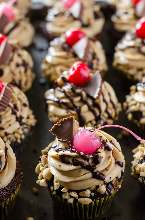 Take a bite of cupcake heaven! Tender chocolate cupcakes, stuffed with hot fudge sauce and topped with peanut butter mousse, these decadent Peanut Butter Hot Fudge Sundae Cupcakes won't melt like ice cream...but you might need a glass of milk to wash them down!
