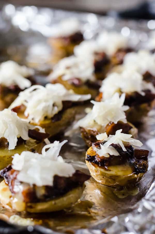 Fall and football season are almost here again, and these mini German Potato Skins can be found on the snack table! Super crispy baby potatoes covered in caramelized onions, beer-braised bratwurst, and a pile of sauerkraut make Game Day so much more delicious!