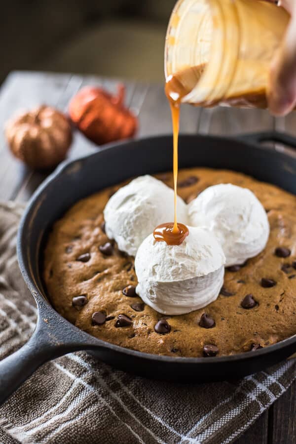 Treat your family to an easy seasonal treat - a big Pumpkin Chocolate Chip Skillet Cookie! Adding pumpkin and spices to classic cookie dough bakes up a soft, chewy cookie that you're gonna need a plate for!