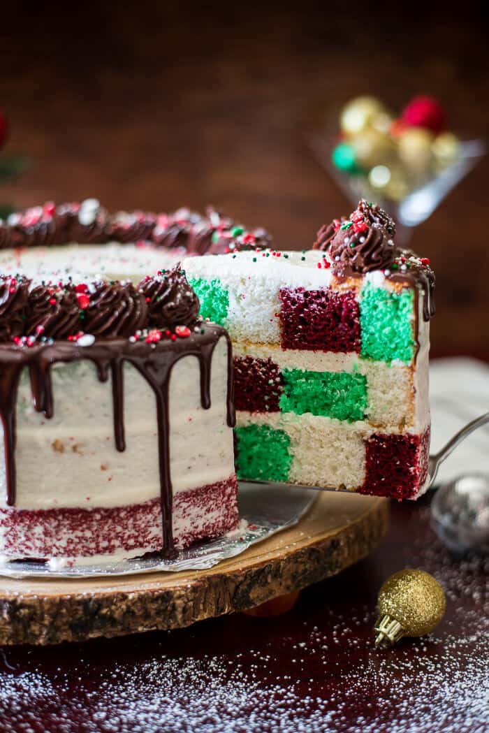 Cake deserves its time to shine on your holiday table, and this Christmas Checkerboard Cake is just the thing that's going to put all the cookies and pies to shame! Three festive colors, two types of icing, and a bunch of sprinkles make this baby the star of the show!