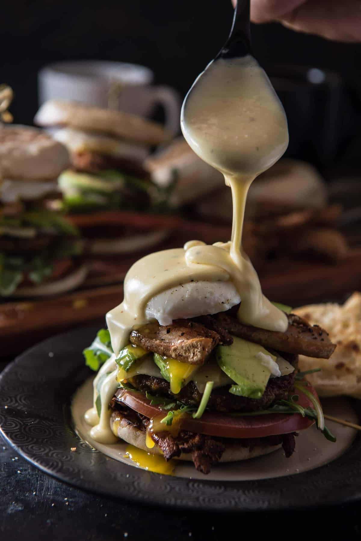 You think you do brunch? The Ultimate Brunch Burger is a foodie's dream - a beef & sausage patty, crispy pork belly, cheddar cheese, hash browns, avocado, a poached egg, tomato, and arugula, all topped with homemade spicy Hollandaise.