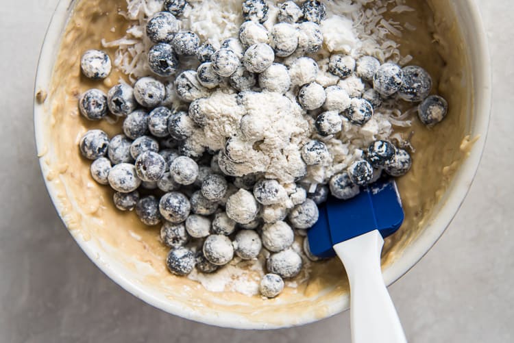 floured blueberries in a bowl of batter
