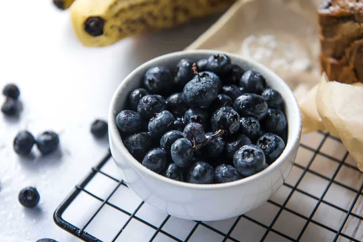 A white bowl of fresh blueberries