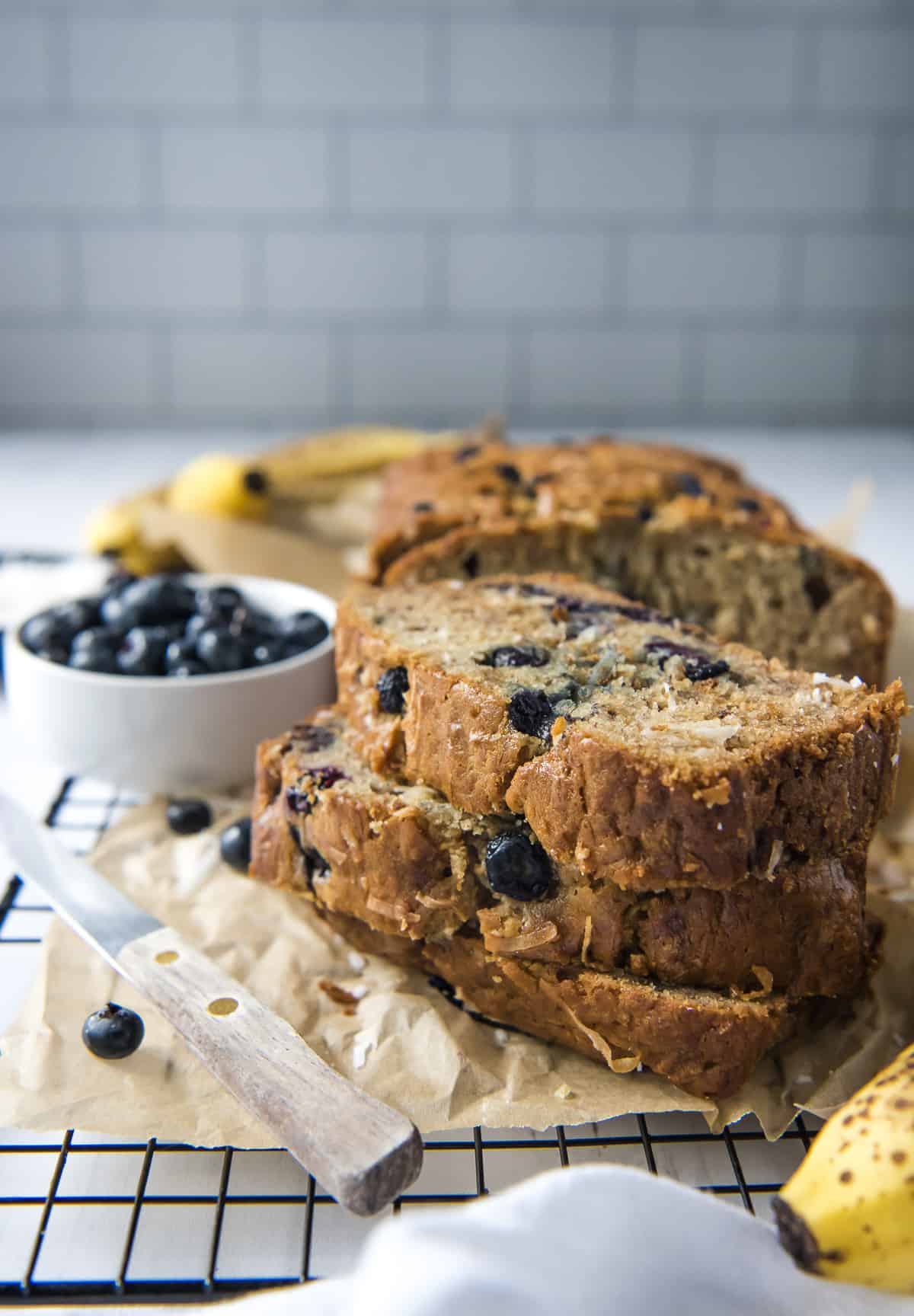 blueberry coconut banana bread slices on a cooling rack