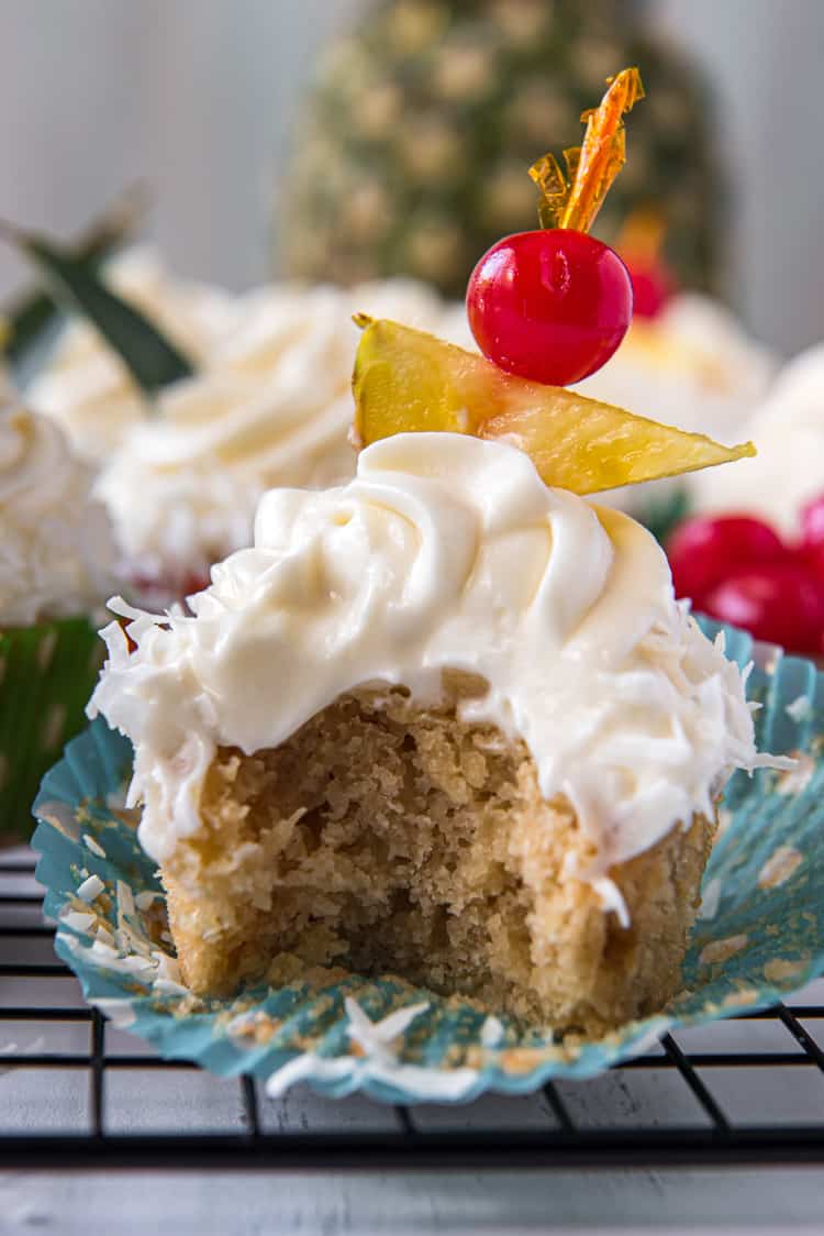 A pineapple cupcake with a bite removed