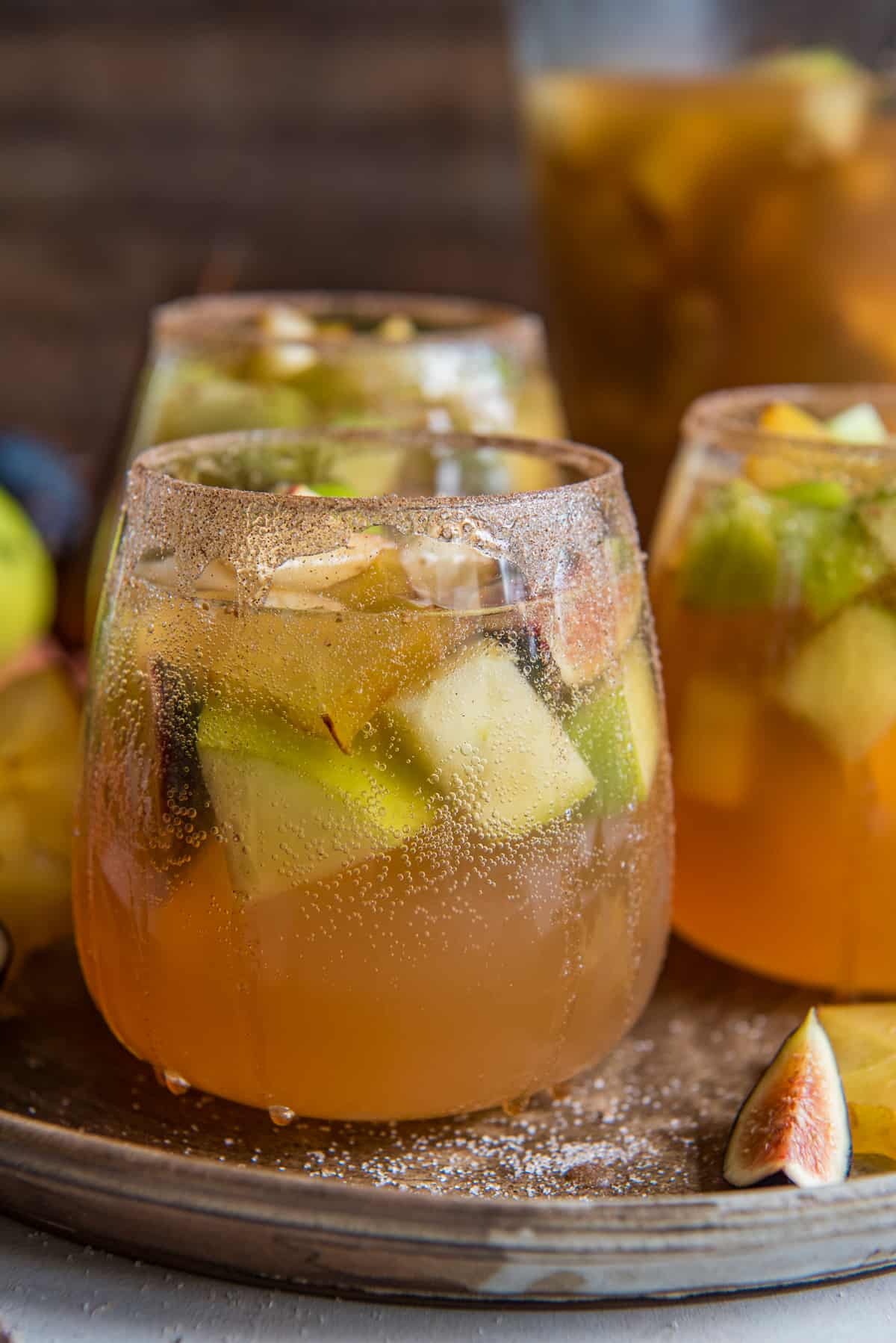 Three glasses of fall sangria with fruit and figs.