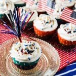 Firecracker Cupcakes | A classic vanilla cupcake, bursting with a slightly tart summer berry compote, and crowned with a halo of fluffy whipped cream cheese frosting.