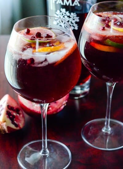 Pomegranate Summer Sangria | Celebrate the warmth of the season with this deep yet refreshing summer sangria, bursting with citrus, dark rum, full red wine, & PAMA Pomegranate Liqueur!