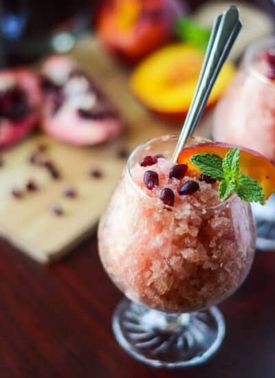 Peach Pomegranate Mojito Granita | Made with fresh mint simple syrup and ripe Georgia peaches marinated in PAMA Pomegranate Liqueur, this fancy shaved Italian ice is a true crowd-pleaser!