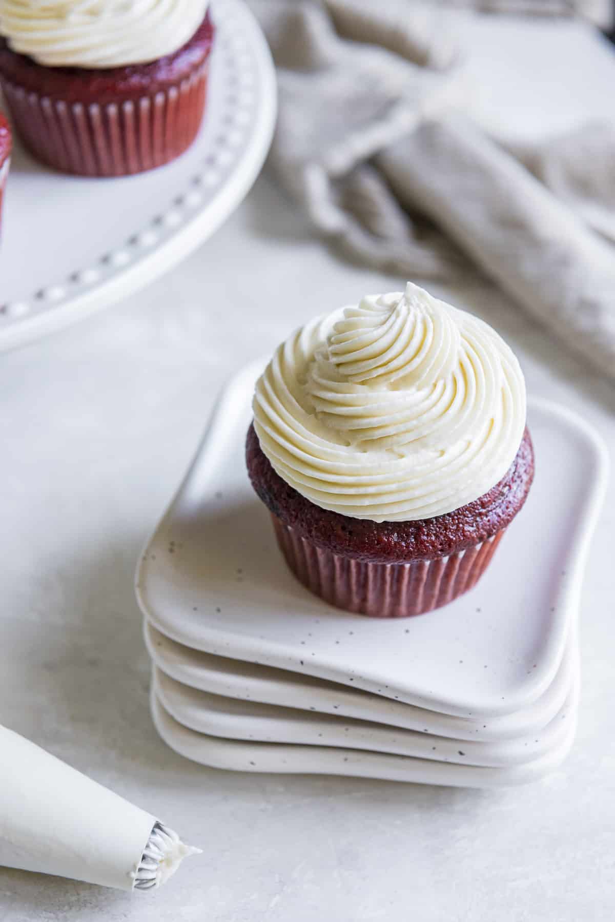 a red velvet cupcake on a stack of white plates