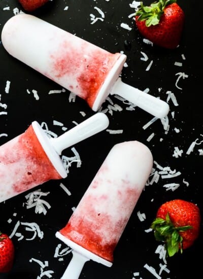 Strawberry Pina Colada Popsicles | A frosty, refreshing treat, made with fresh fruit and coconut milk, sweetened with agave, and spiked with coconut rum for the grown ups!