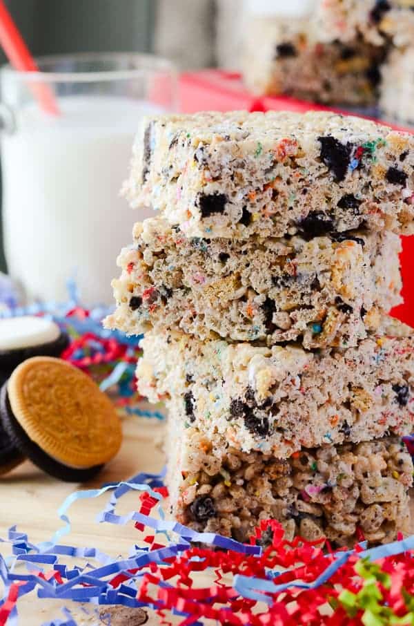 A stack of Oreo Rice Krispie Treats with milk and Oreos in the background