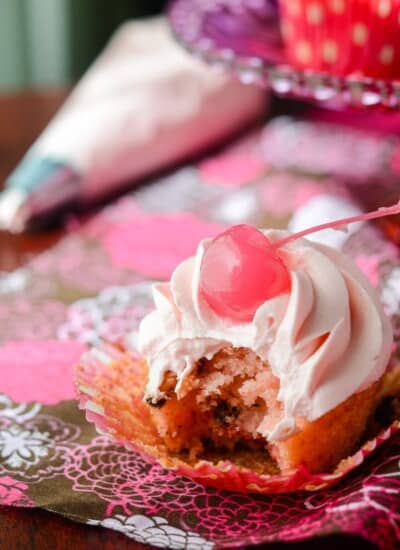Cherry Chocolate Chip Cupcakes with Pink Chocolate Buttercream | Think pink! These delightful maraschino cherry chocolate chip cupcakes are topped with a fluffy pink chocolate buttercream, and were baked (and eaten!) for a great cause!