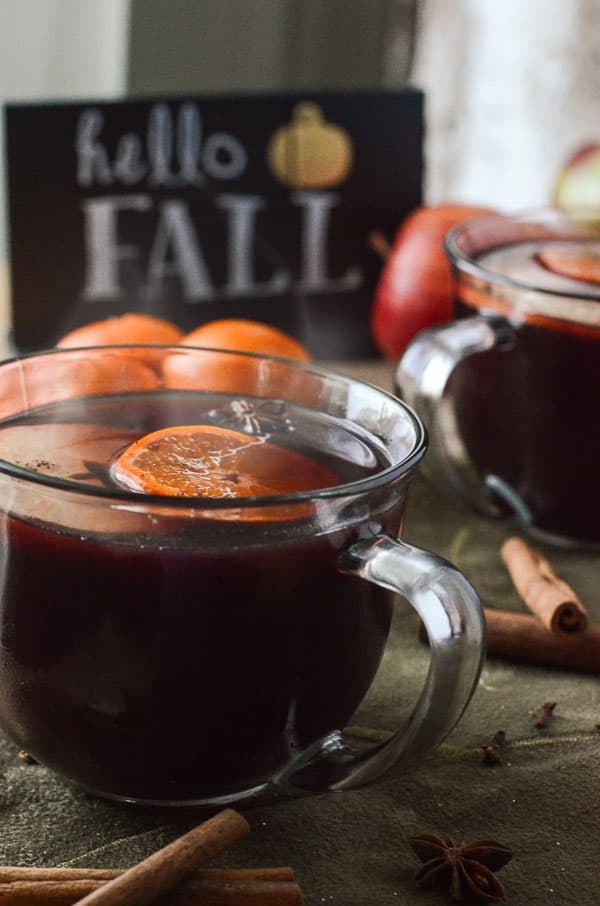 Hot Mulled Apple Cider Sangria | It's the perfect time of year for drinks like this! Hot apple cider and red wine, blended and mulled with honey, apples, clementines, and seasonal spices, then spiked with spiced rum.