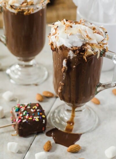 Toasted Coconut Almond Hot Cocoa | This delicious hot cocoa is made with real chocolate, cream of coconut, and almond milk, and garnished with all the goodness of an old favorite candy bar - it's a wonderfully satisfying way to warm up this winter!