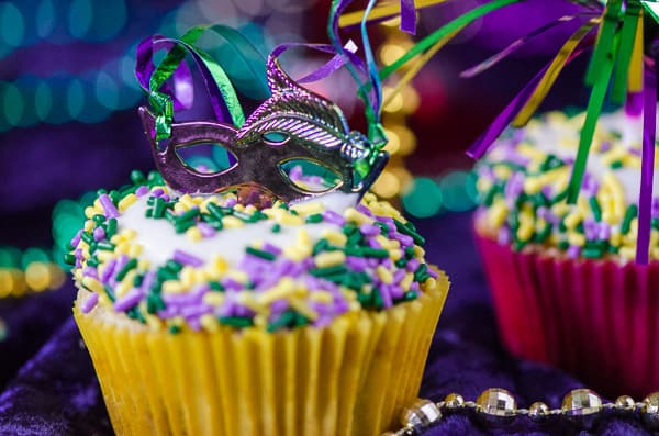 King Cake Cupcakes | Laissez les bons temps rouler! Celebrate Mardi Gras with these fun and festive moist vanilla cupcakes, swirled with cinnamon sugar and topped with cream cheese glaze and festive sprinkles!