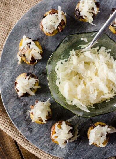 Cheesy German potato bites on a plate with a spoon.