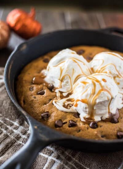 Treat your family to an easy seasonal treat - a big Pumpkin Chocolate Chip Skillet Cookie! Adding pumpkin and spices to classic cookie dough bakes up a soft, chewy cookie that you're gonna need a plate for!