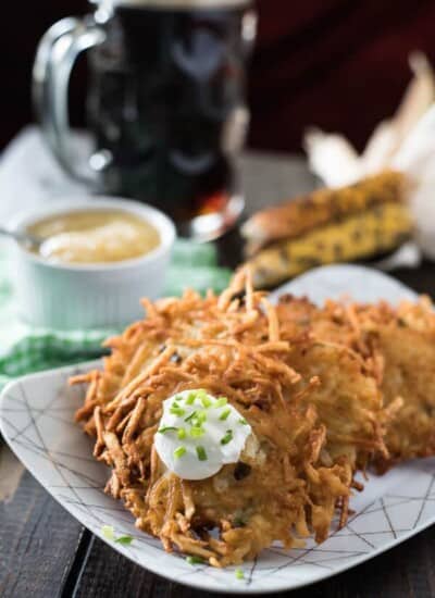 German potato pancakes, also known as kartoffelpuffer, are served on a plate along with a refreshing beer.