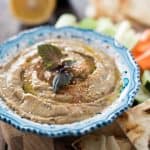 A simple appetizer that will thrill vegans as well as meat-eaters! Smokey, slightly chunky, and loaded with flavor, this traditional eggplant Baba Ganoush recipe is kicked up with a touch of cumin and paprika, plenty of garlic, and fresh Meyer lemon juice.