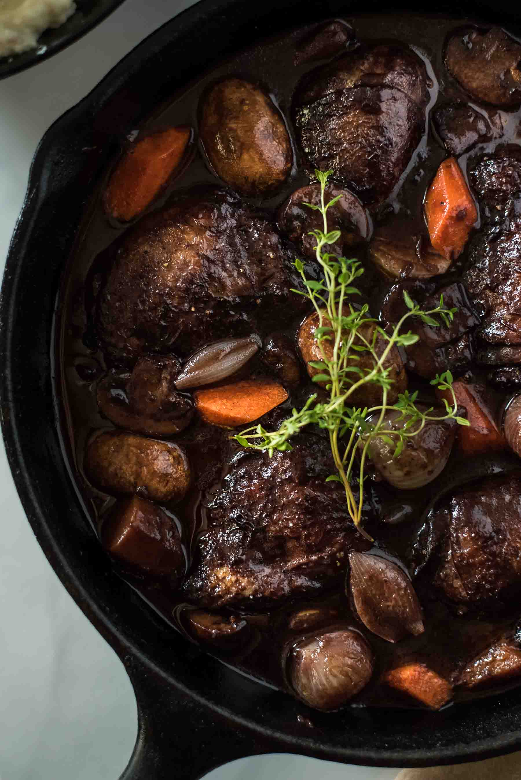 No fear - this classic Coq Au Vin recipe is not nearly as difficult as you might think! Wine-marinated chicken, onions, mushrooms, and carrots are slow simmered in a deliciously rich French red wine sauce, and will be the highlight of your week at the dinner table!