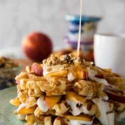 These deliciously easy Peach Cobbler Waffles with Honeyed Yogurt should be on your breakfast menu this weekend! Buttermilk waffles, lightly sweetened with yogurt & fresh peaches, then stacked and topped with honeyed yogurt and granola - nothing says summer quite like these!