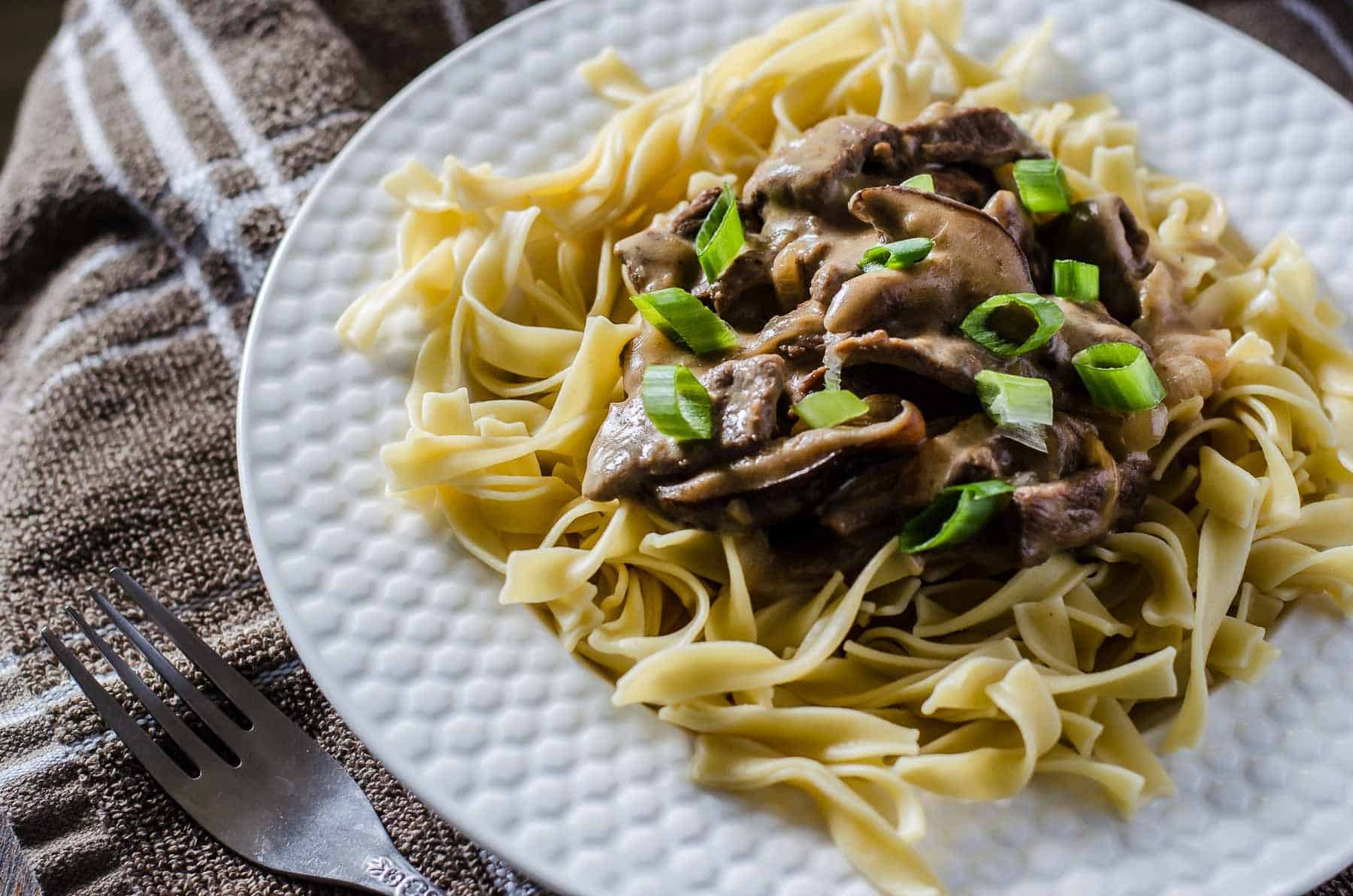 This classic Beef Stroganoff recipe comes together in less than 30 minutes! Choose your favorite cut of steak and cook it in an amazing creamy mushroom sauce, then serve it all over egg noodles for a fabulous hot lunch or dinner.