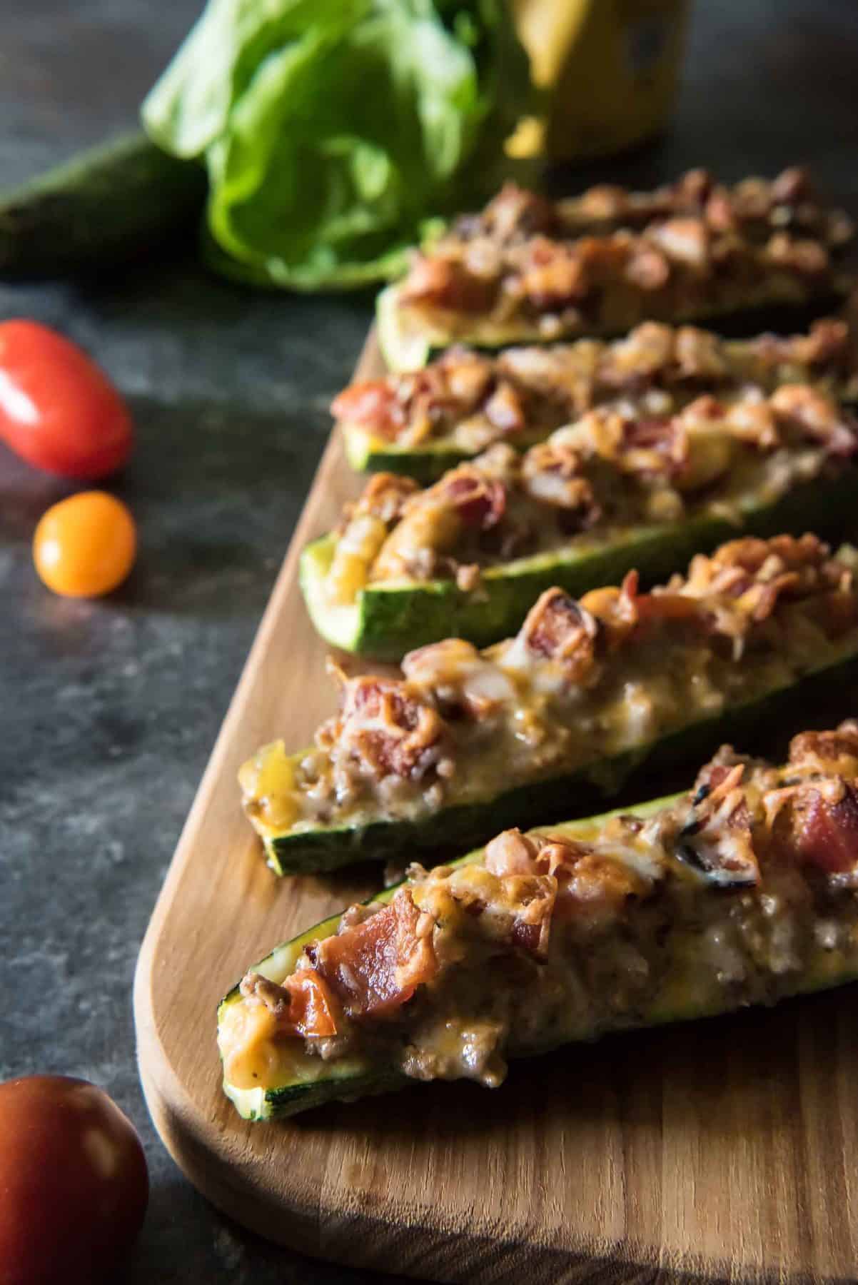 ground beef zucchini boats lined up on a cutting board