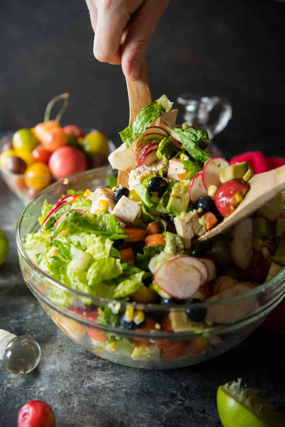 Summer lovin' in a salad! Grilled chicken, grilled corn, fresh cherries, blueberries, and avocado are tossed with standard salad fare and a tangy lime vinaigrette - creating a crunchy Summer Chopped Salad that's perfect for any meal!