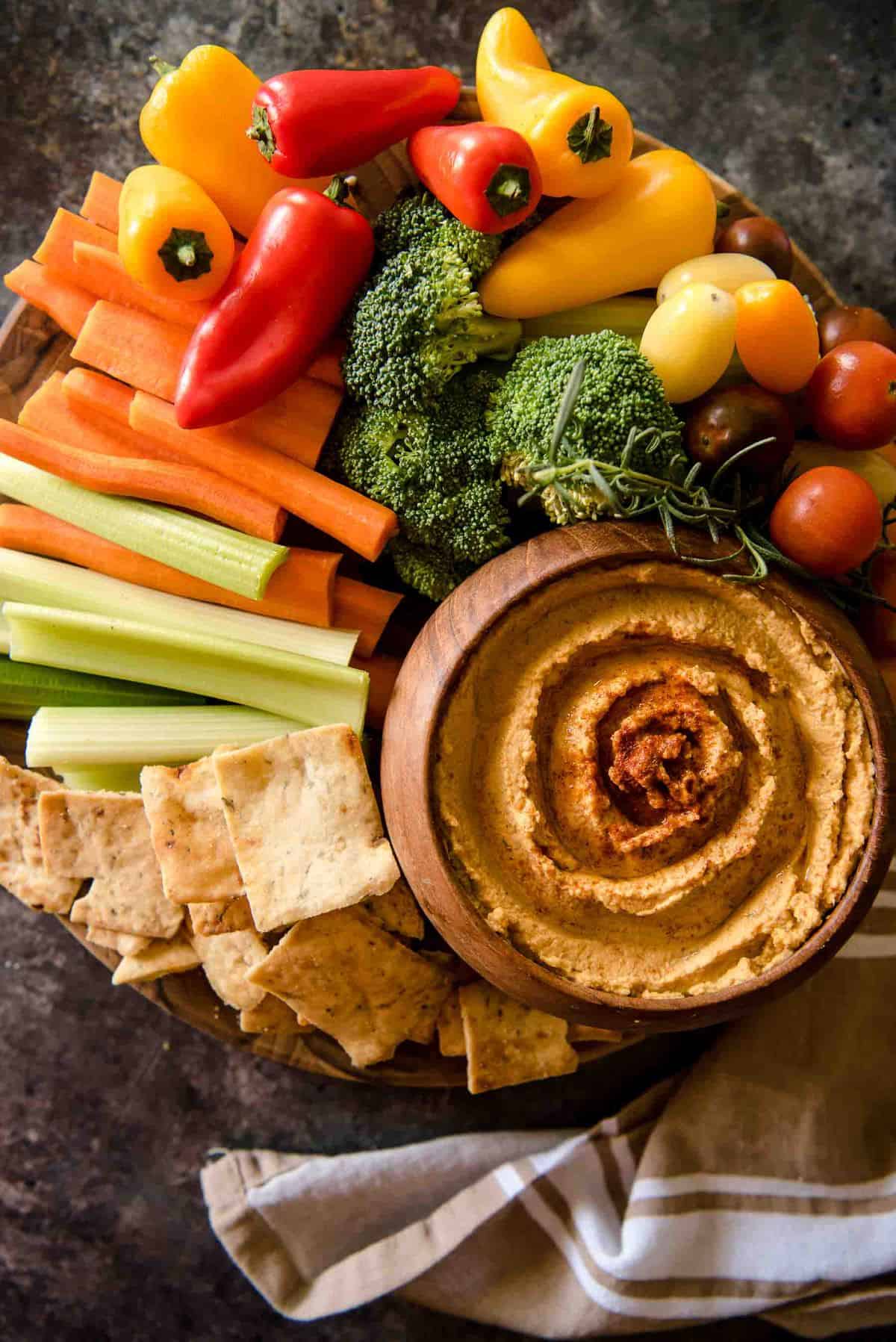 Everything you love about your favorite hummus with a little bit of fall added in - this savory Roasted Garlic Pumpkin Hummus takes just 5 minutes to make, and will please every palate!