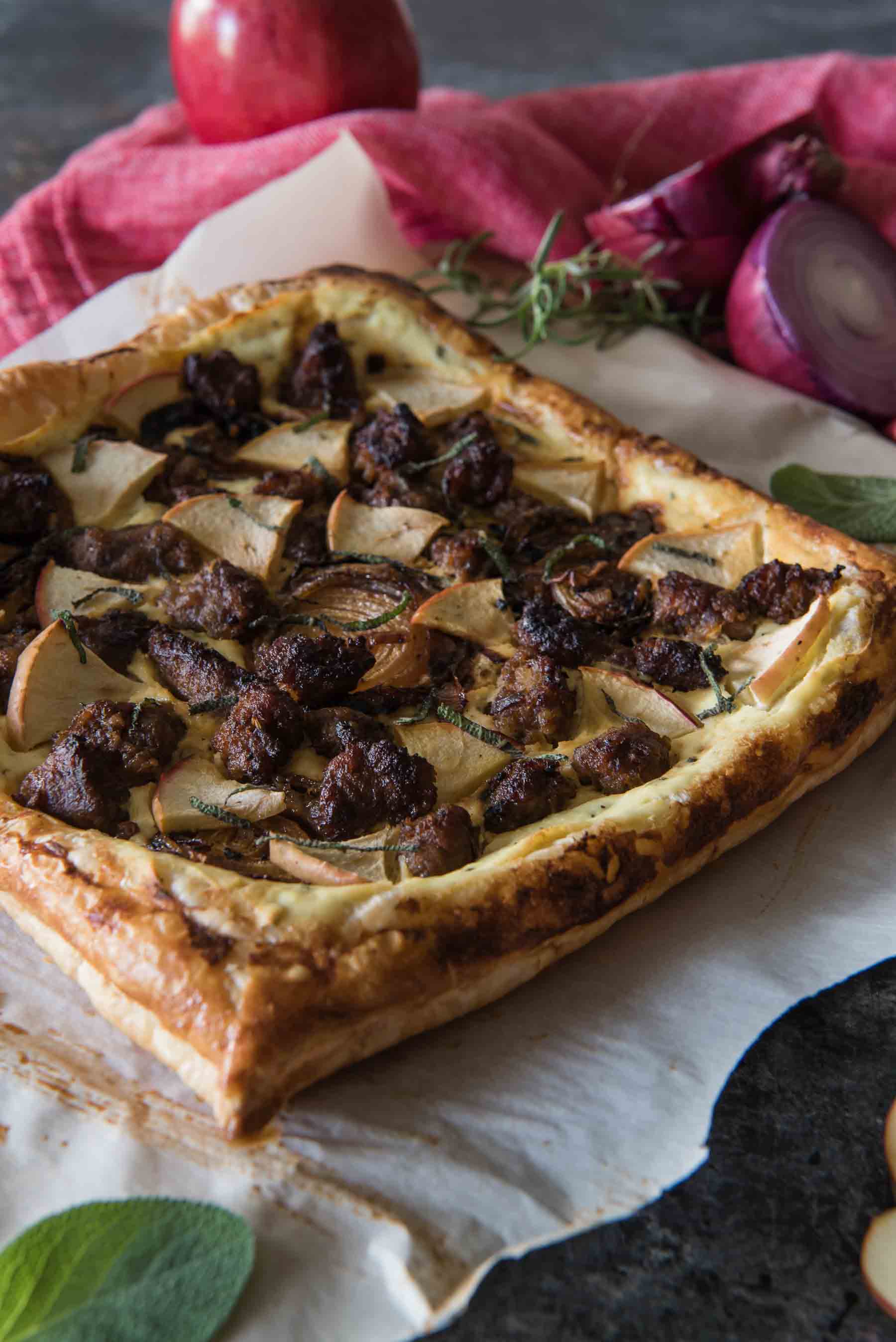 Caramelized onions, spicy Italian sausage, and sweet apple on an herbed ricotta, spread over puff pastry - whether served as an appetizer or snack, this Savory Apple Sausage Tart is sure to please any fall flavor-loving crowd! 