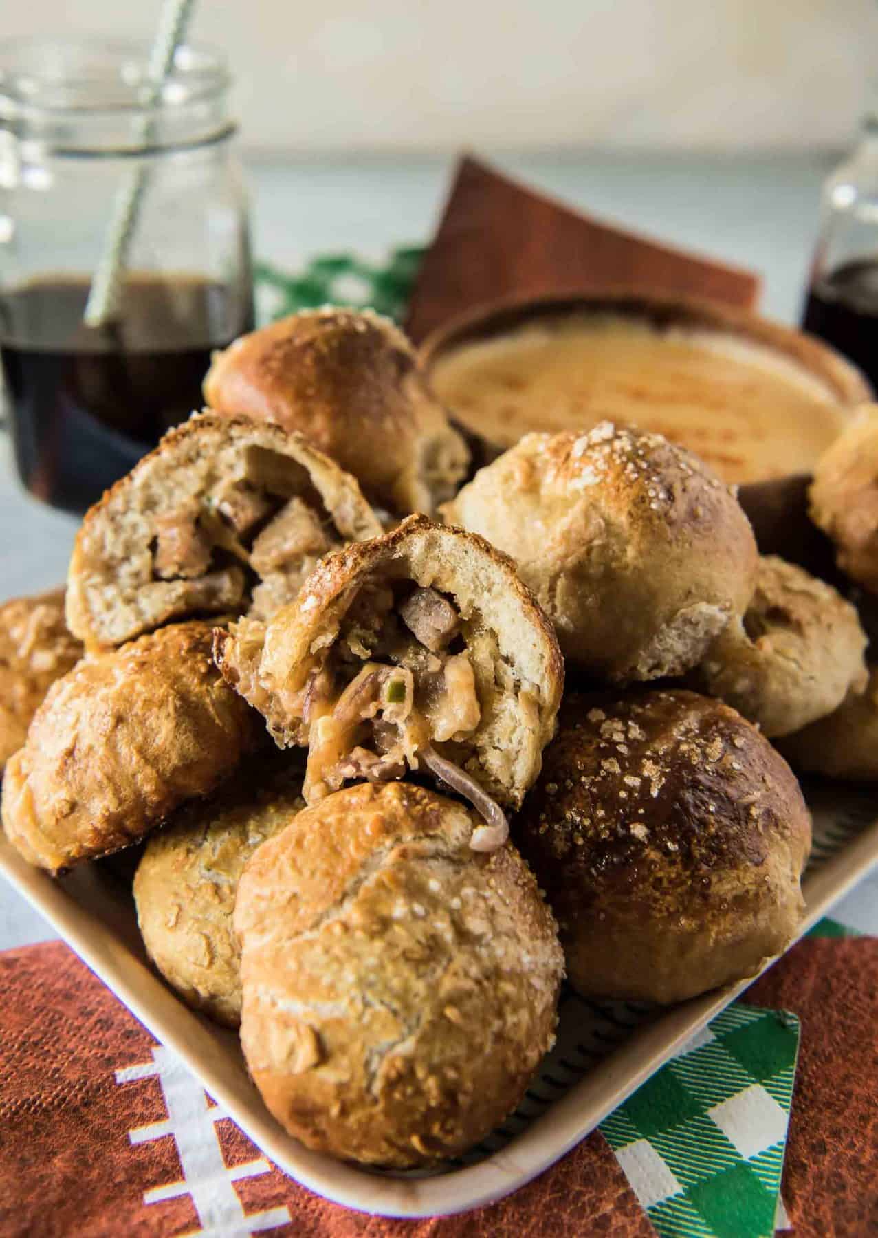 Sweet & Spicy Bratwurst Pretzel Bombs: fluffy balls of baked pretzel dough, filled with chopped bratwurst, cheese, diced fresh jalapenos, and caramelized onions. Homemade beer cheese dip will make these everyone's fave appetizer!