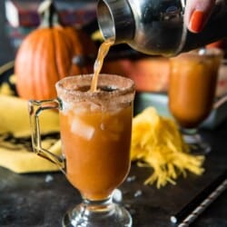 A person pouring a glass of spiked pumpkin juice