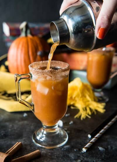 A person pouring a glass of spiked pumpkin juice