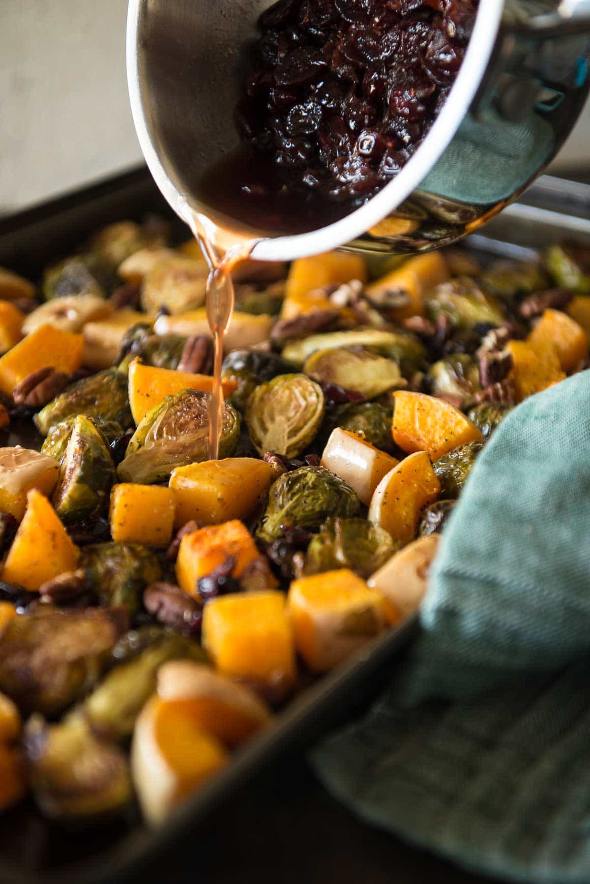 Caramelized veggies, roasted with pecans and tossed with a sweet and tangy glaze - these Roasted Brussels Sprouts & Squash With Cranberry Cider Glaze might be the perfect holiday side dish! 