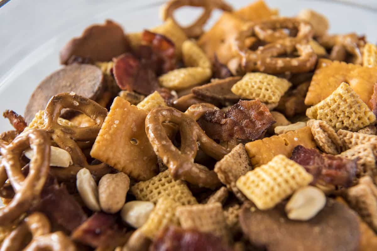 a close up shot of bourbon bacon chex mix in a bowl