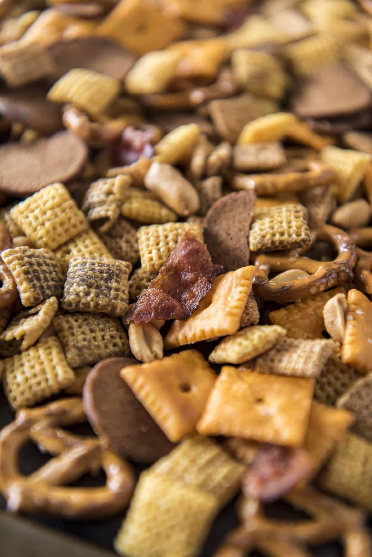 a close up shot of bourbon bacon chex mix on a sheet pan