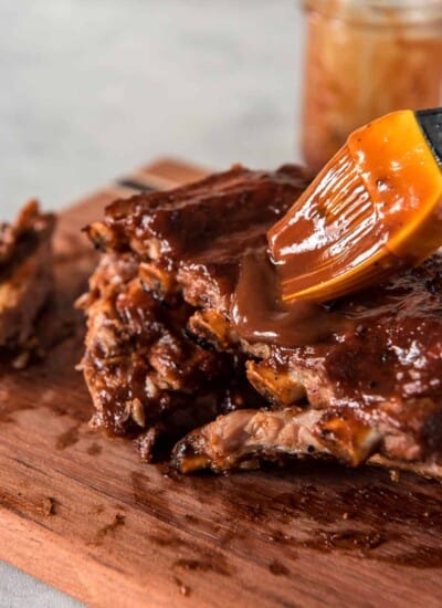 Instant Pot baby back ribs with bourbon barbecue sauce on a cutting board.